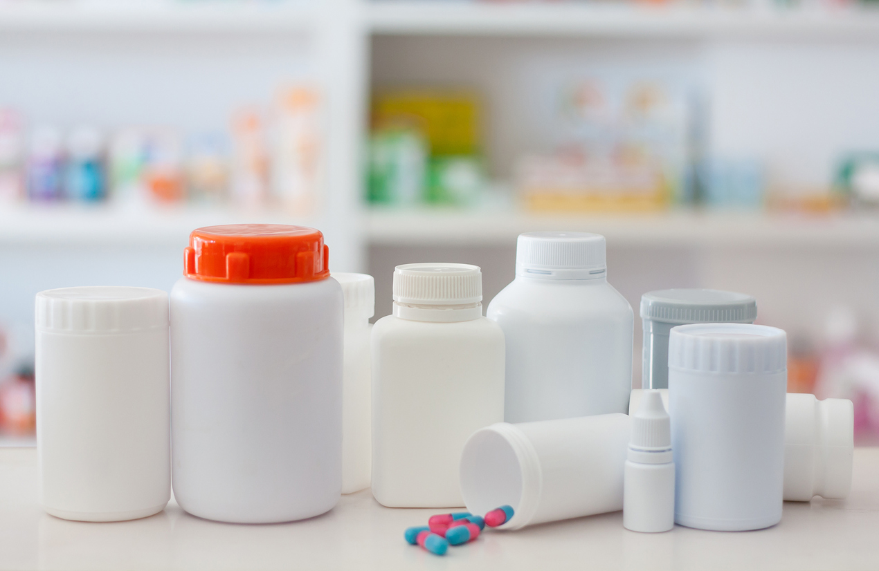 Composition of medicine bottles and pills with pharmacy store shelves background