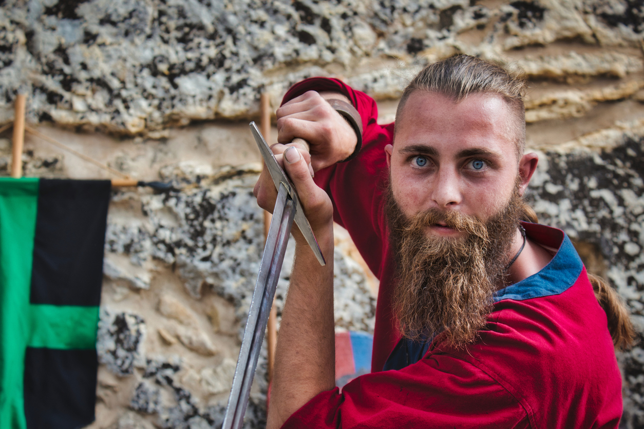A bearded viking brandishing a steel broadsword