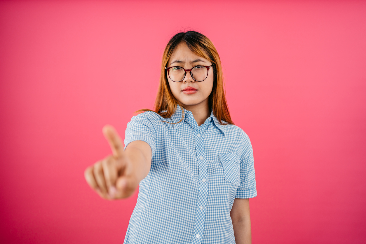 Displeased Woman Waving Her Finger Against A Pink Background
