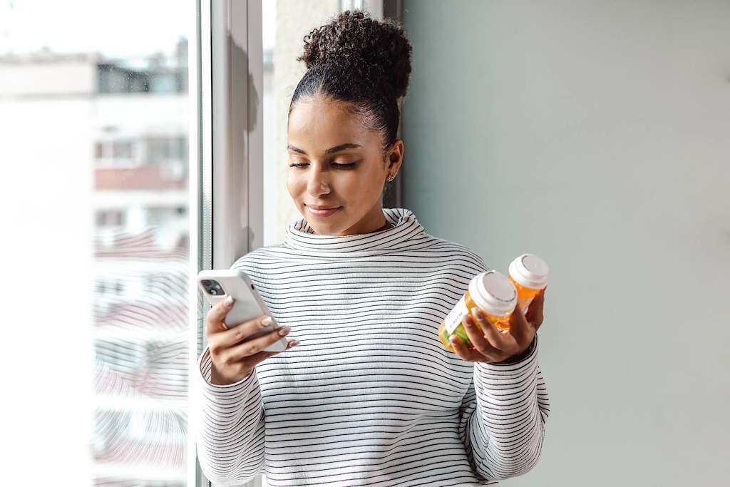 person looking at phone with prescription